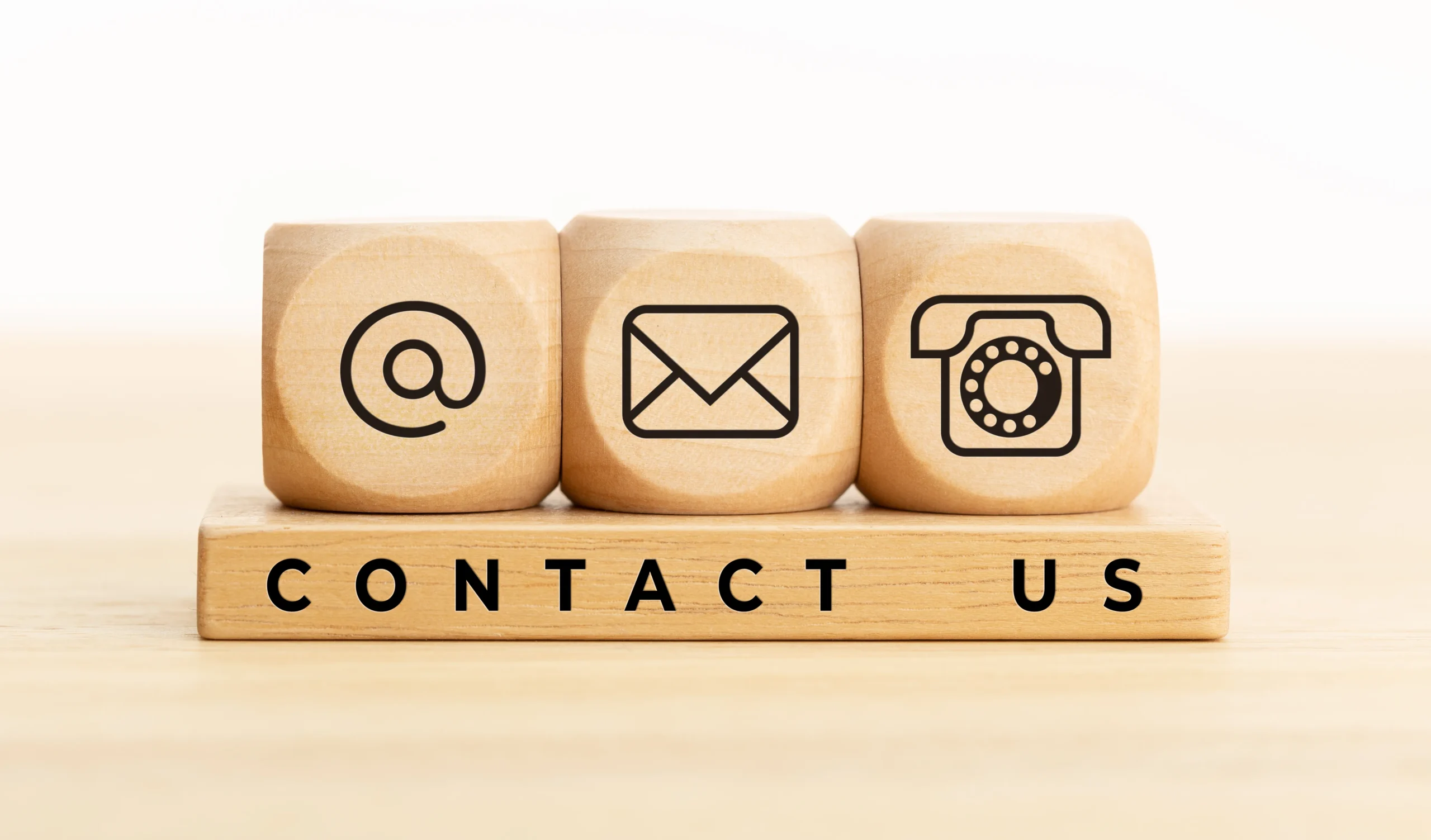 Contact Us wooden blocks with icons for email, mail, and telephone customer support for OEM skincare, cosmetics, and dietary supplement manufacturing factory inquiries.
