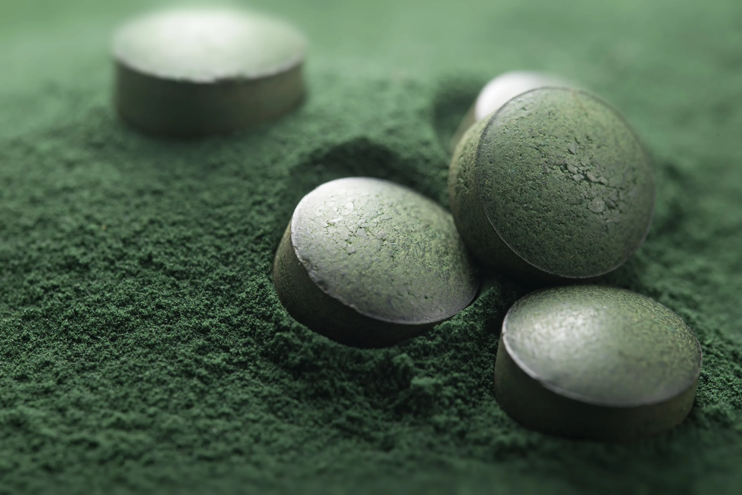 Green anti-aging supplement pills and extract powder representing holistic longevity and NAD+ precursors for 2027 supplement manufacturing trends.